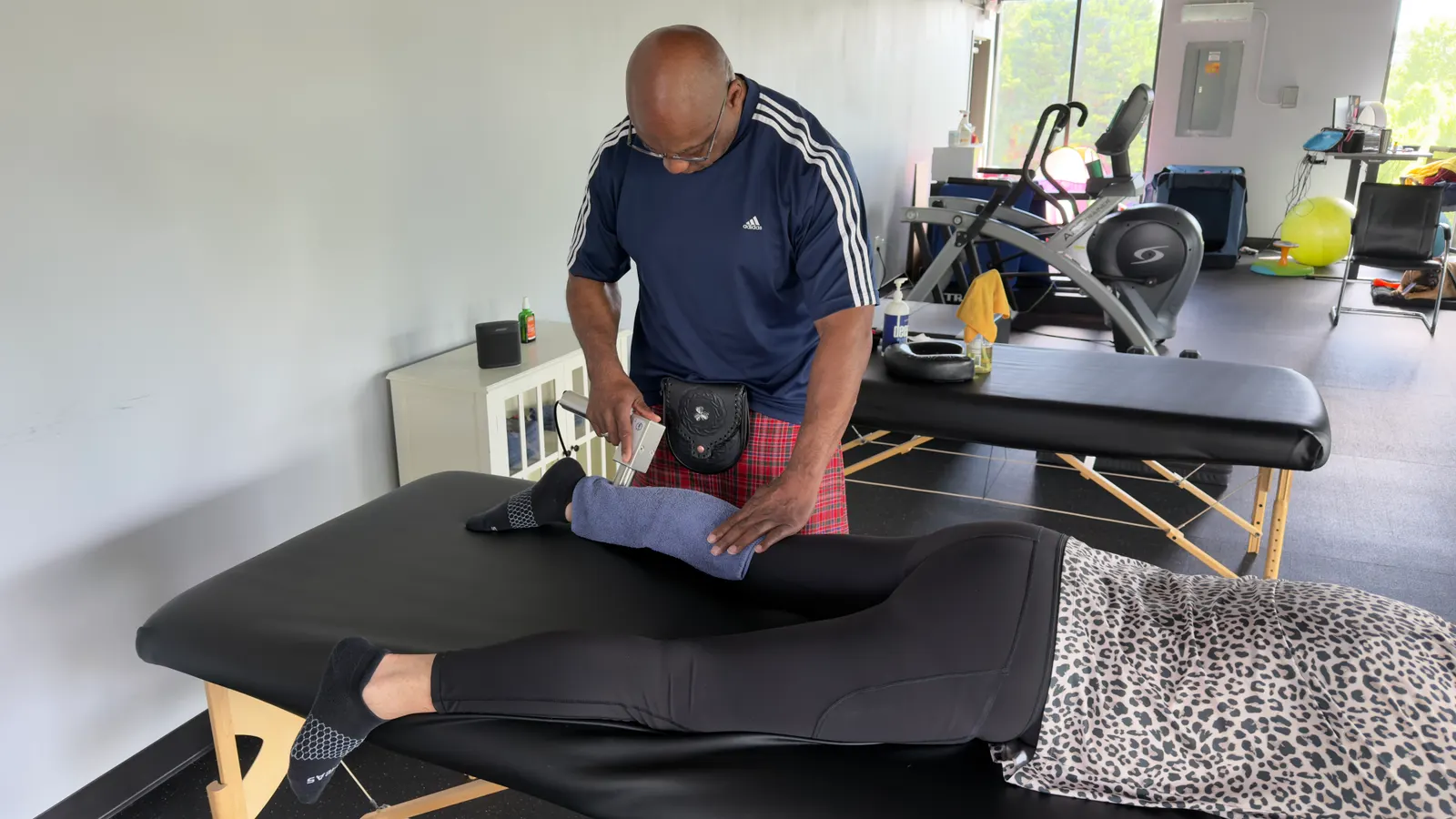 Bill McCallister performing hands-on soft-tissue work on a client at the treatment table